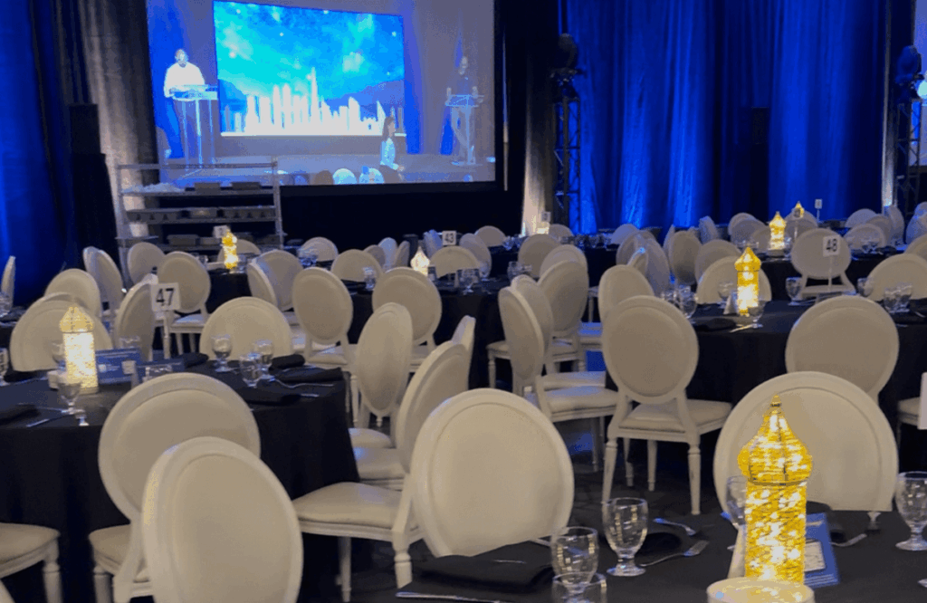 A long table set for a fancy dinner, perfect for a wedding or gala.